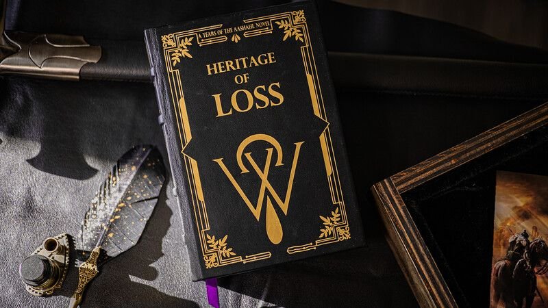 The hardcover edition of Heritage of Loss: black boards blocked in gold with the Tears sigil, beside a quill and inkwell.